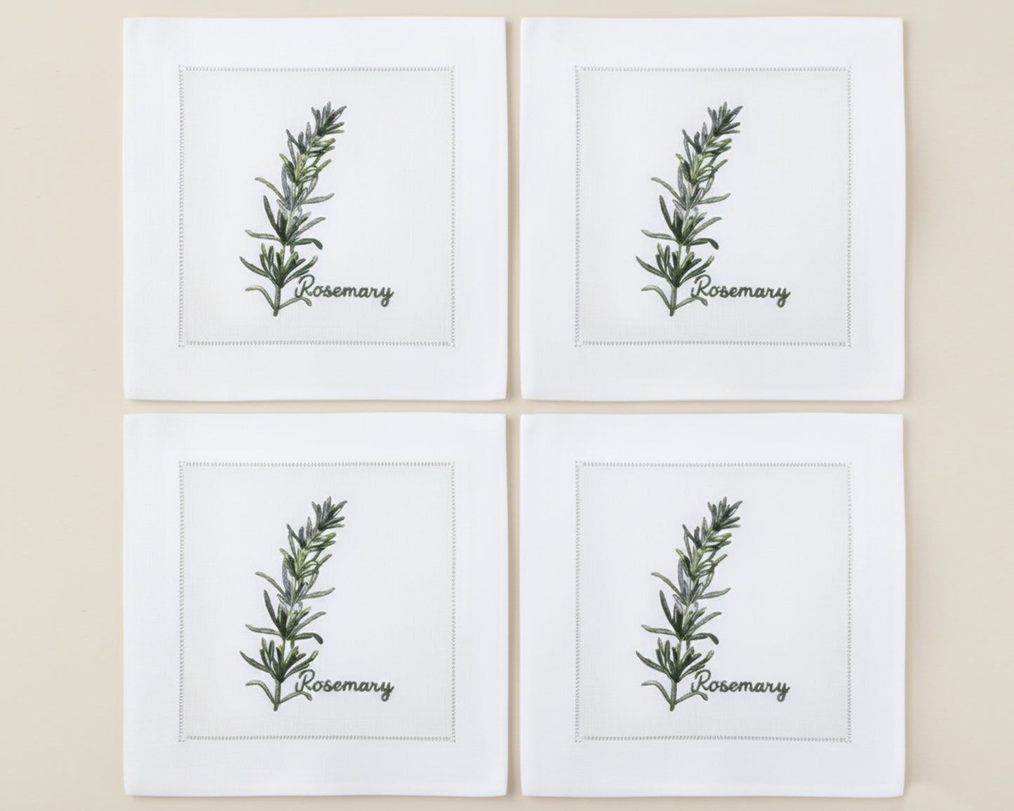 Single white linen cocktail napkin featuring a detailed purple-flowered Rosemary sprig embroidery with a hemstitch edge.