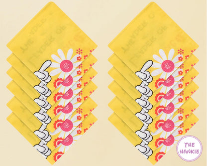 Stack of yellow hankies with floral design on a beige background