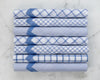Set of six folded blue and white checkered hankies on a marble surface