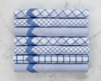 Set of six folded blue and white checkered hankies on a marble surface