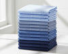 Stack of folded blue towels on a white surface with a light background