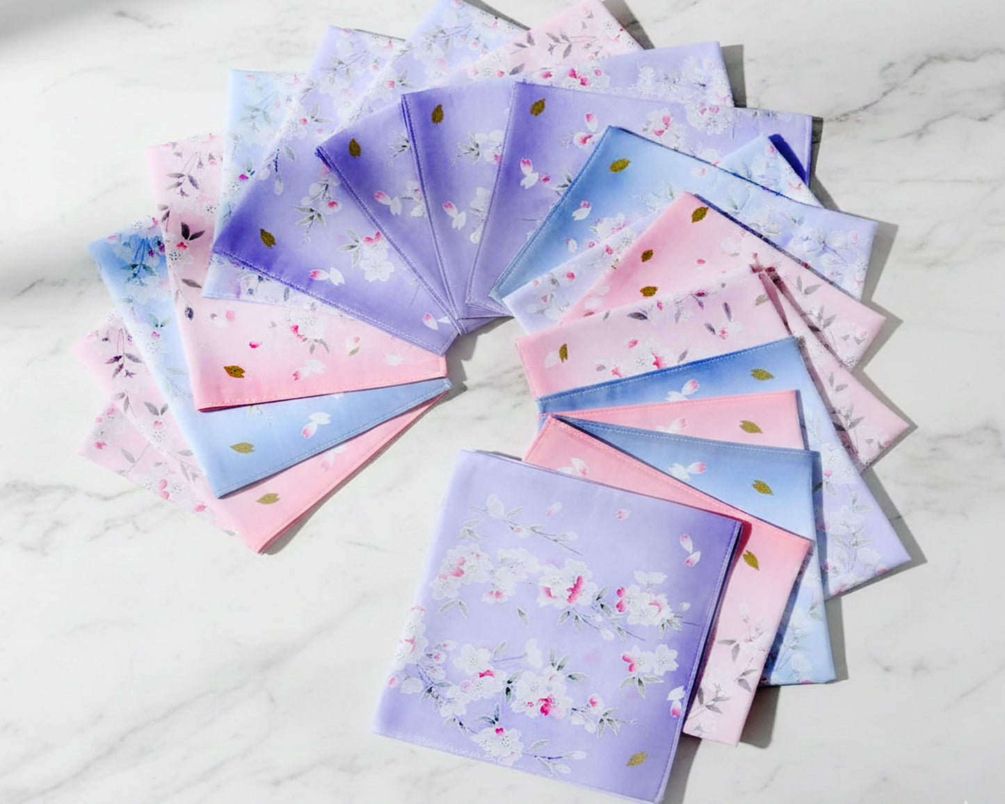 Set of colorful fabric swatches with floral patterns hankies on a white marble surface
