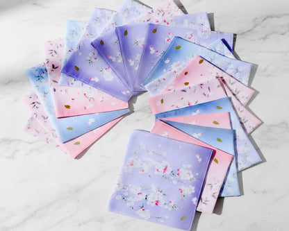 Set of colorful fabric swatches with floral patterns hankies on a white marble surface
