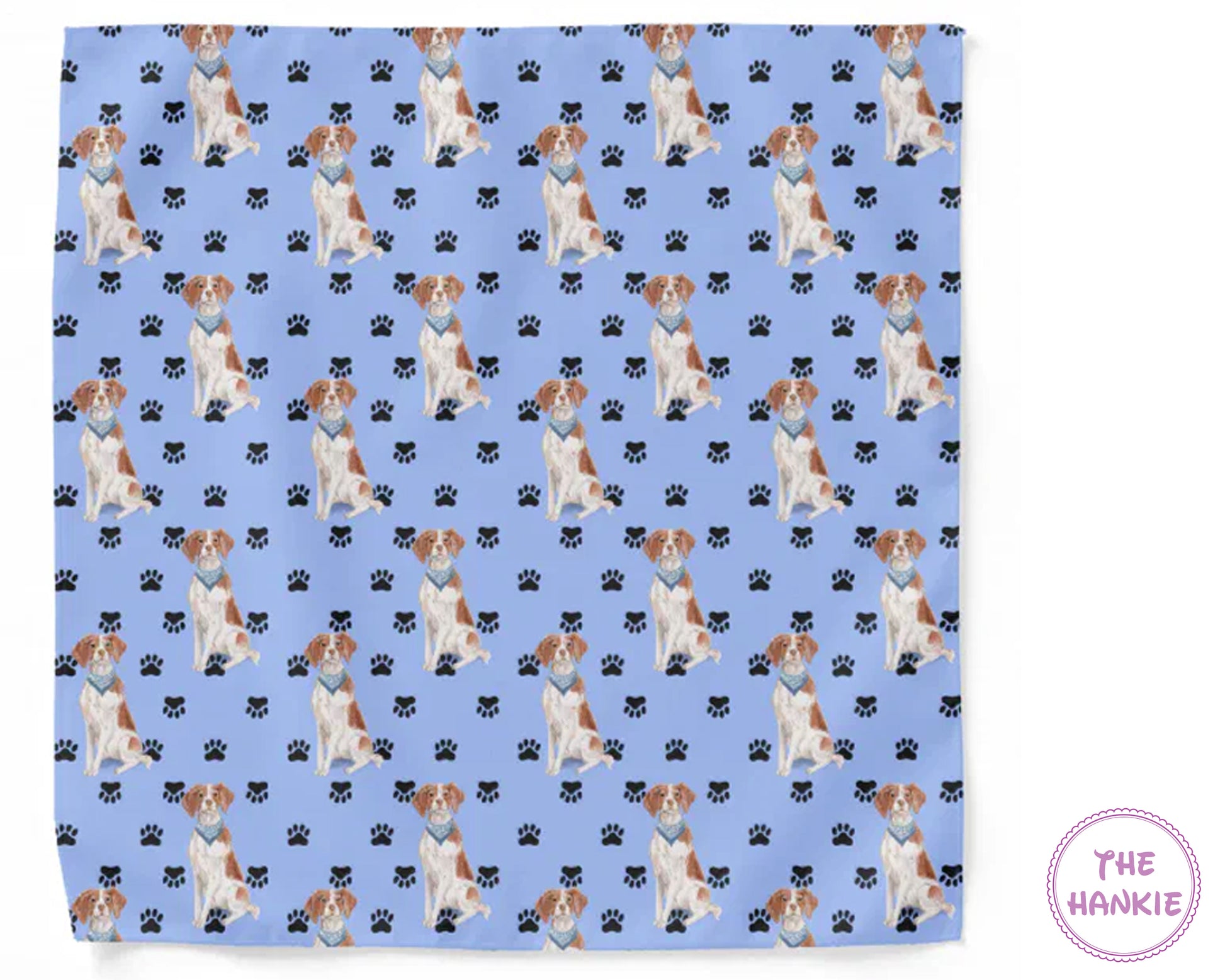 Patterned fabric with dogs and paw prints on a blue background, featuring 'The Hankie' brand.