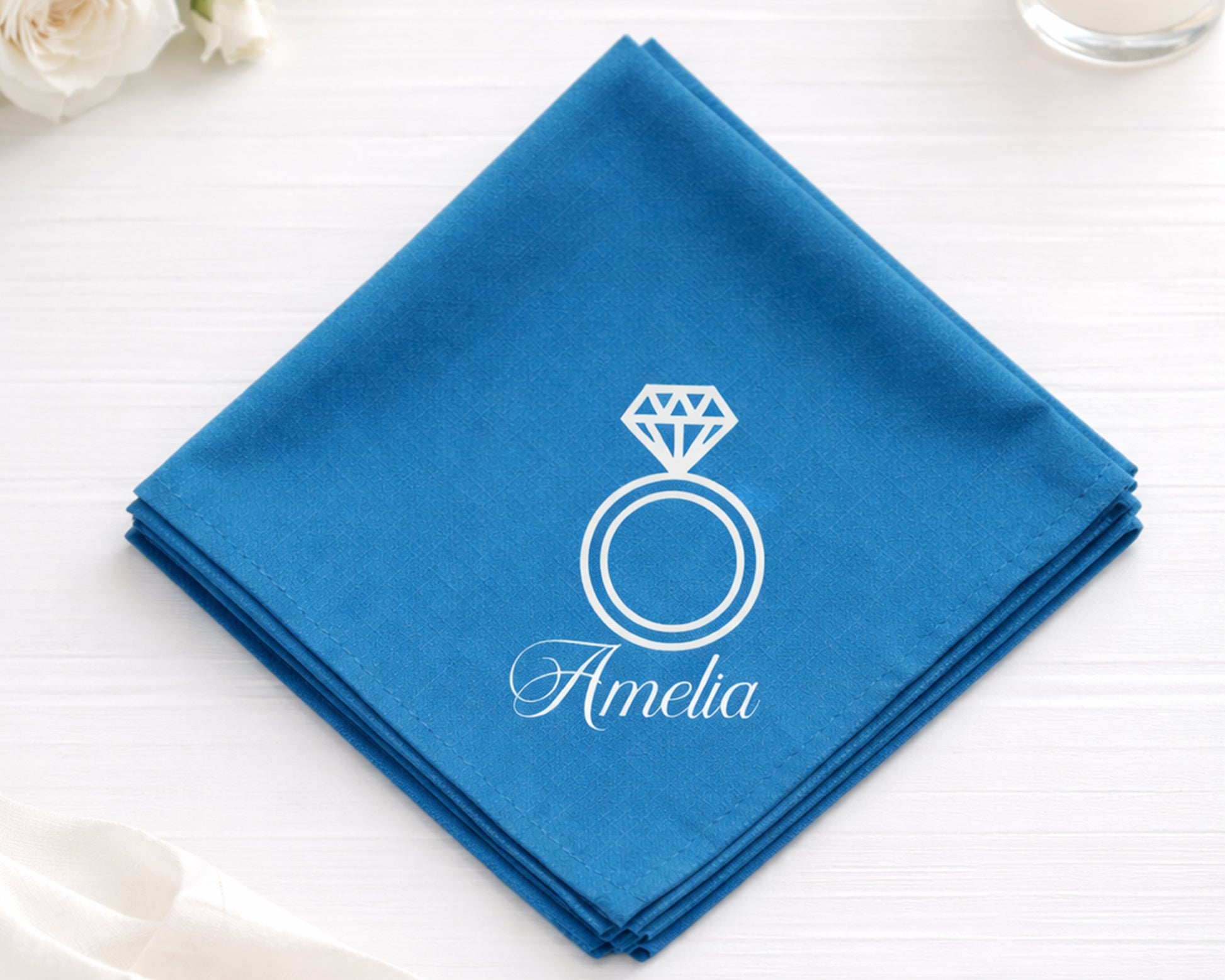 Blue hanky with a diamond ring design and 'Amelia' text on a white surface.