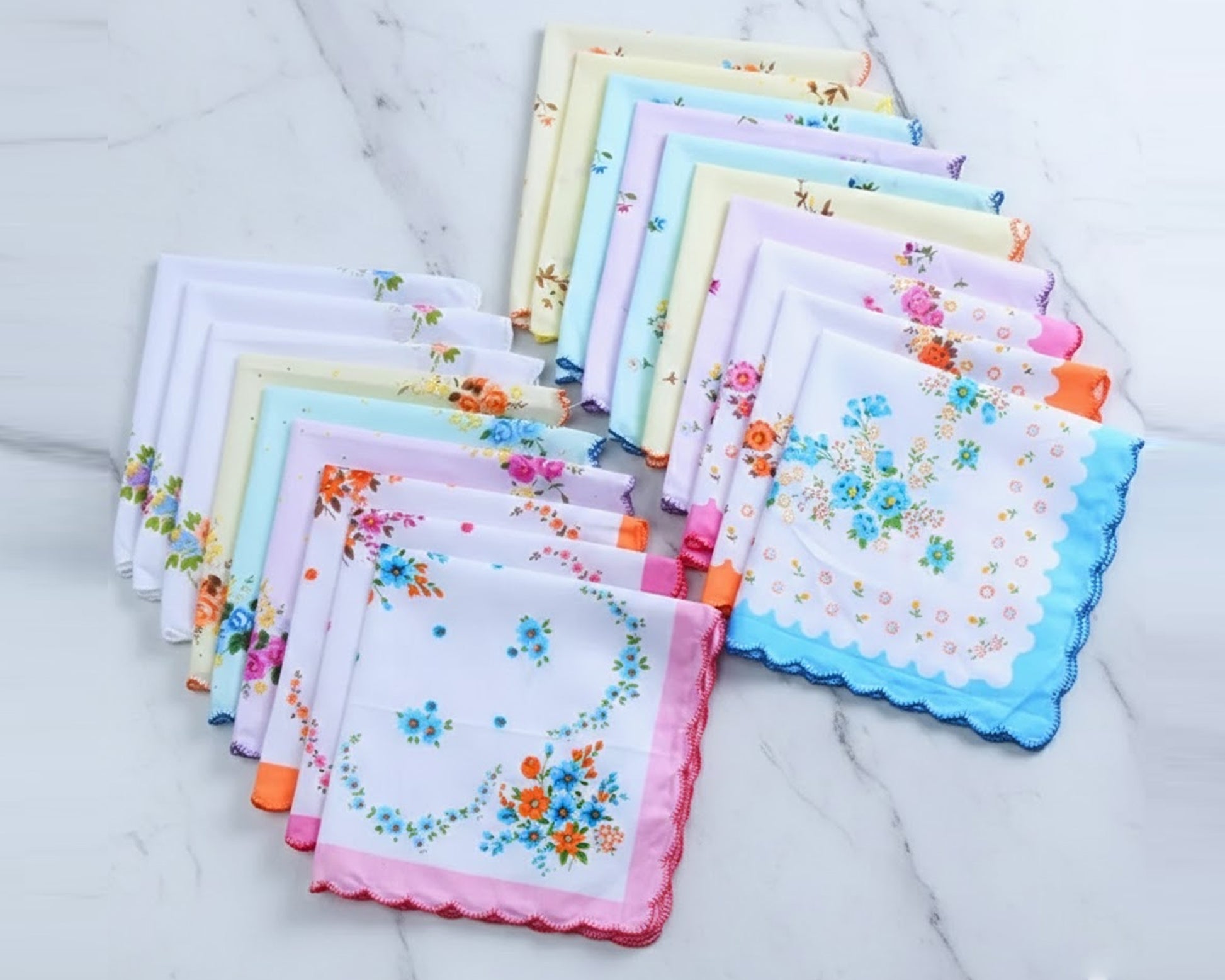 Collection of colorful floral handkerchiefs on a marble surface