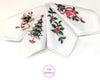 Set of four white hankies with Christmas-themed embroidery on a white background.