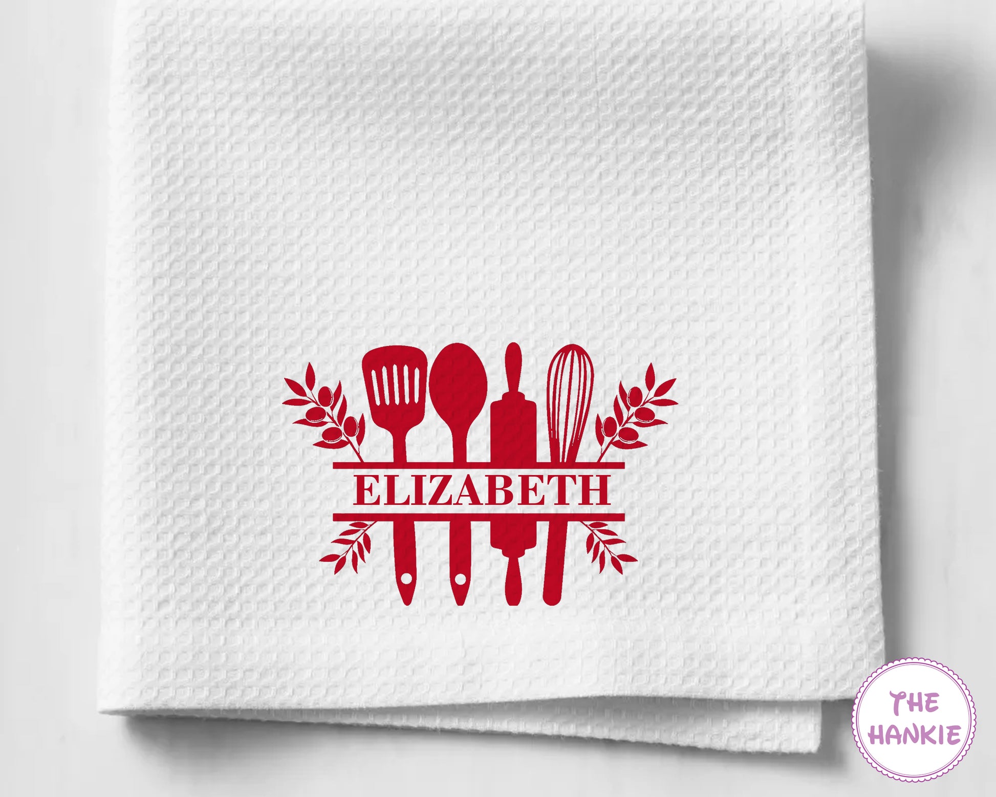 White kitchen towel with red kitchen utensil design and 'Elizabeth' text on a white background