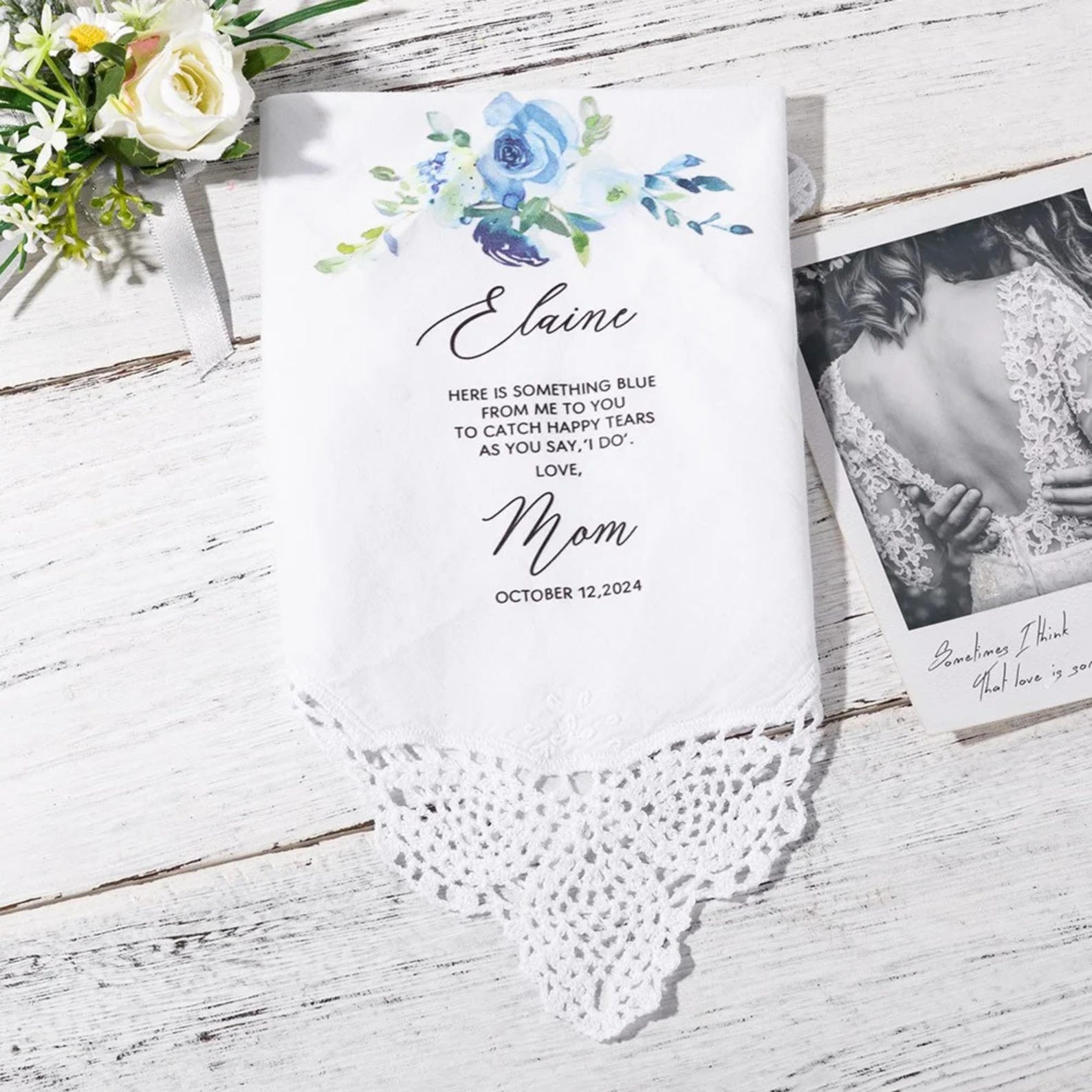 Personalized handkerchief with floral design and text on a wooden surface with flowers and a photo.