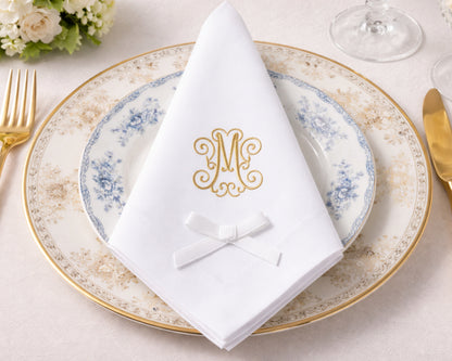 Elegant table setting with a decorative plate, napkin, and cutlery on a light background.