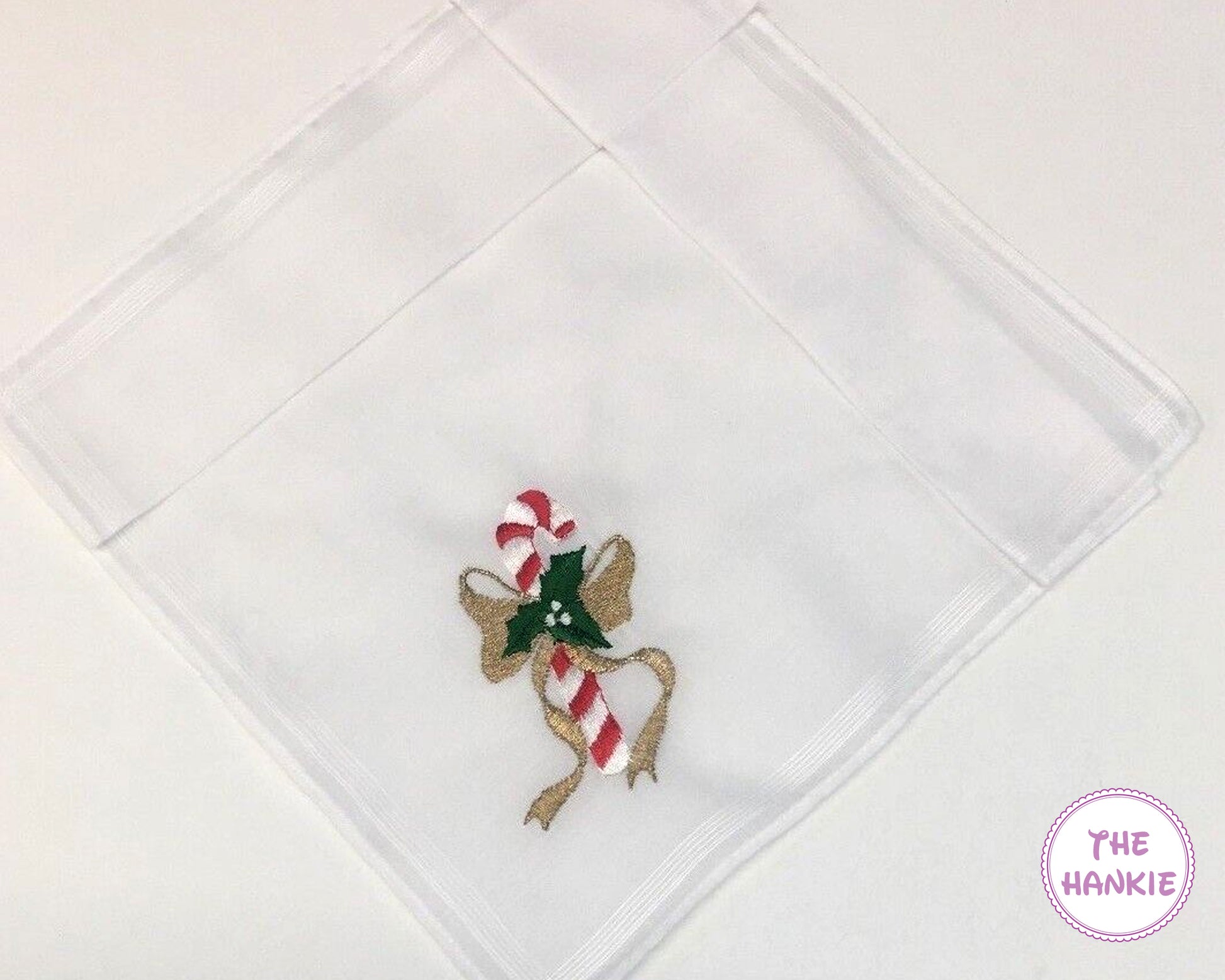 White hankie with a candy cane and bow design on a white background