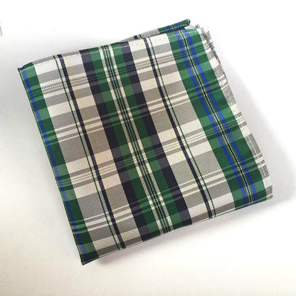 Plaid fabric with green, white, and blue pattern on a white background