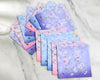 Set of floral fabric swatches handkerchiefs set in pastel colors on a marble surface
