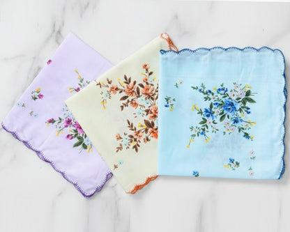 Three floral handkerchiefs in purple, yellow, and blue on a light background