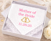 Handkerchief with 'Mother of the Bride' and wedding date embroidery in a box on a wooden surface.