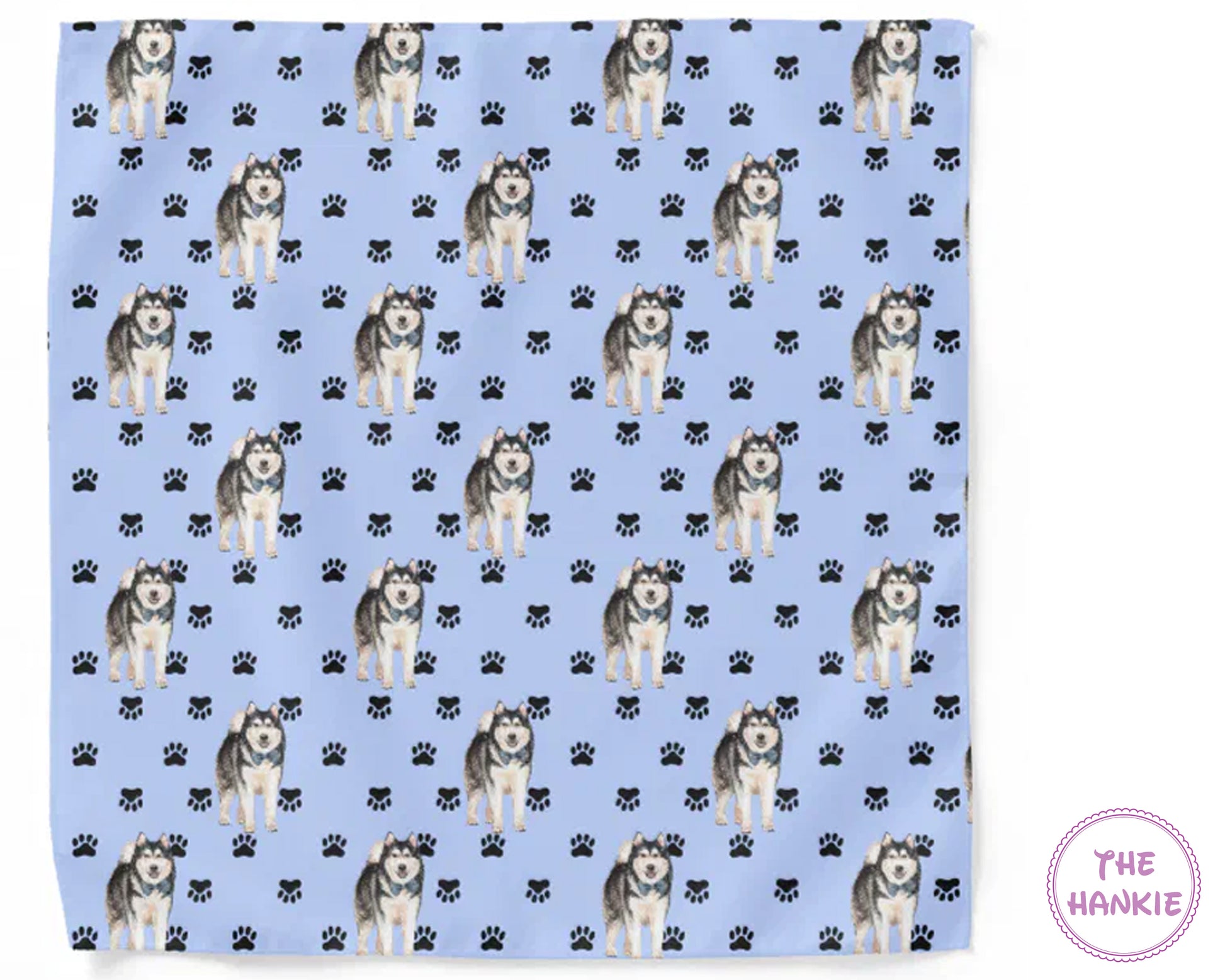 Patterned towel with husky dogs and paw prints on a blue background, branded 'The Hankie'.