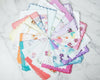 Set of colorful handkerchiefs with floral patterns arranged in a circular fashion on a marble surface.