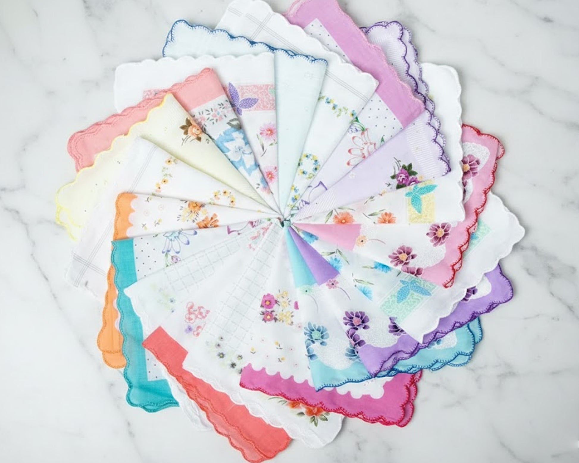 Set of colorful handkerchiefs with floral patterns arranged in a circular fashion on a marble surface.