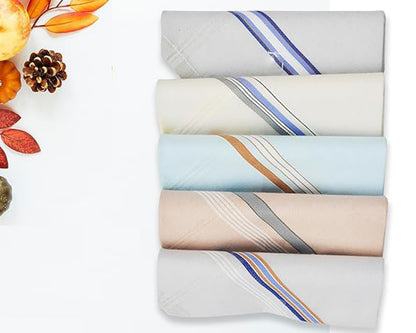 Folded men's cotton handkerchiefs in assorted light shades with bold, multicolored border stripes – pack of 5, displayed flat with autumn decor.