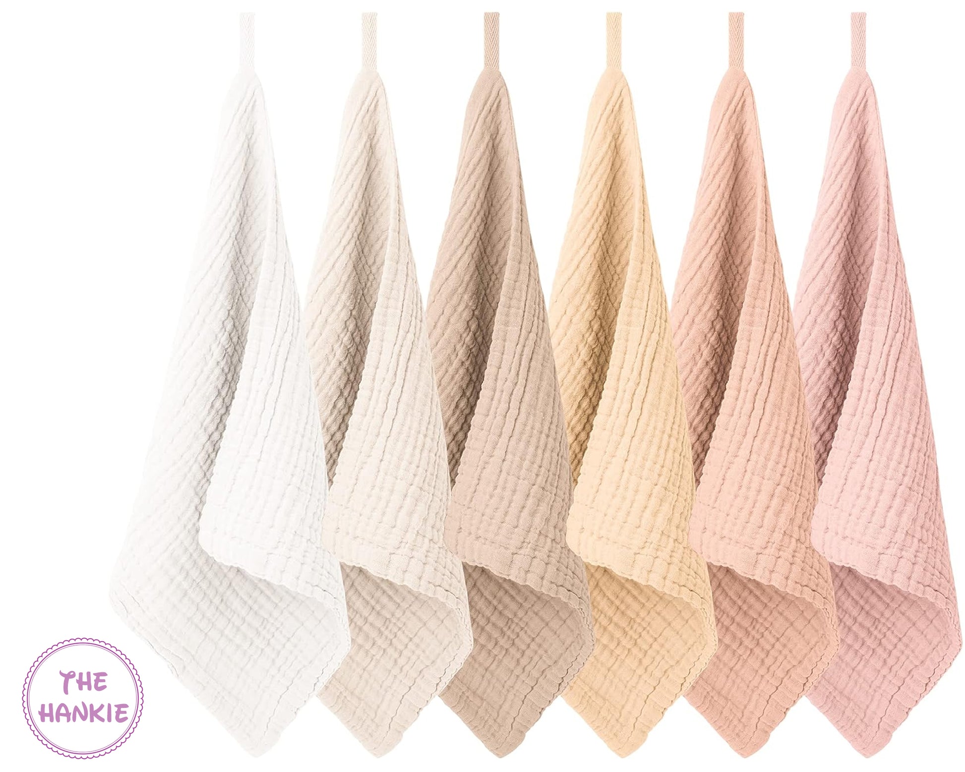 Set of five soft, textured towels in various pastel colors hanging against a white background.