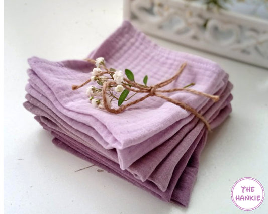 Stack of purple hankies tied with twine on a white surface, with 'The Hankie' brand visible.