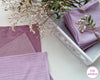 Purple hankies on a white surface with dried flowers