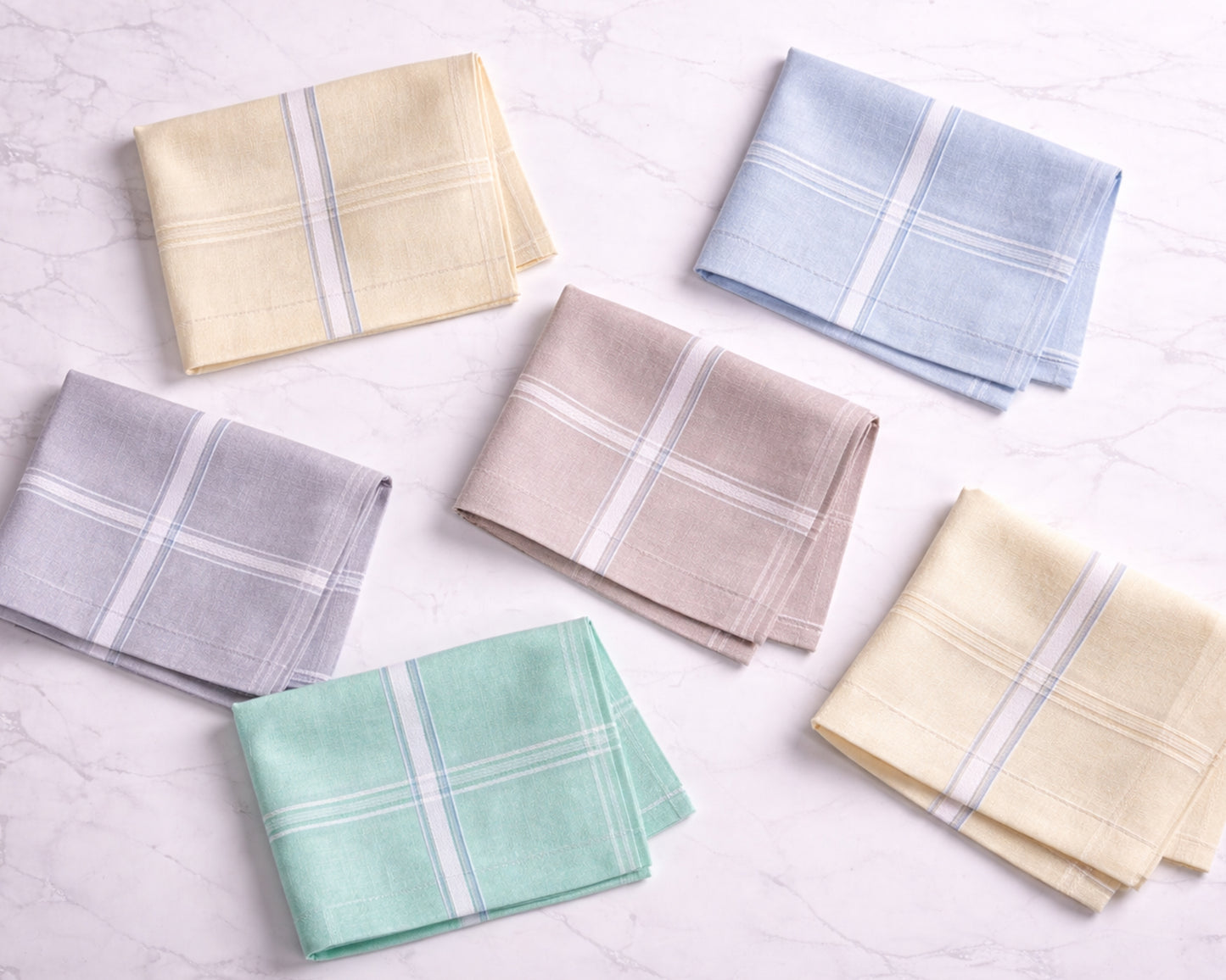 Set of folded handkerchiefs in various colors on a light background