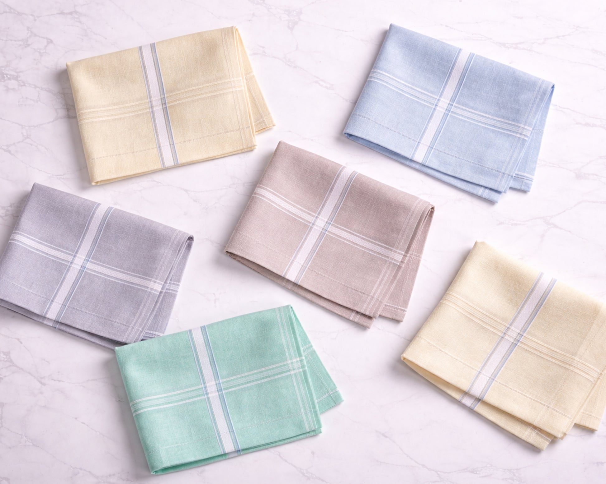 Set of folded handkerchiefs in various colors on a light background