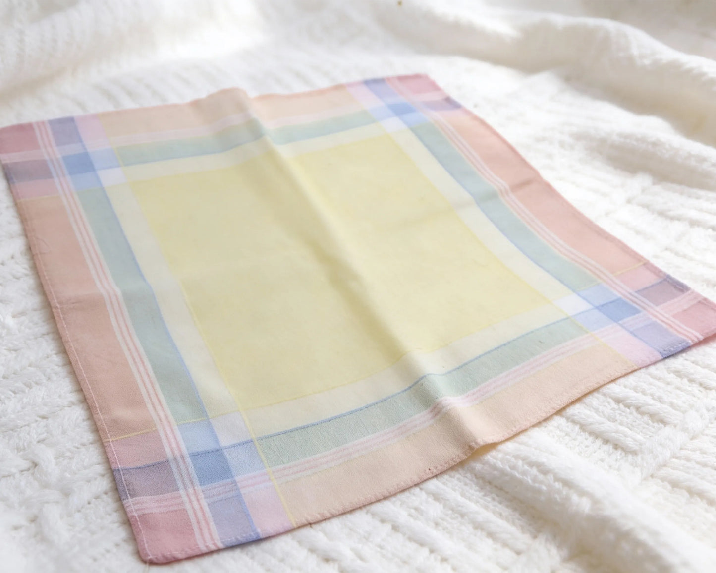 Pastel checkered hanky on a white textured surface