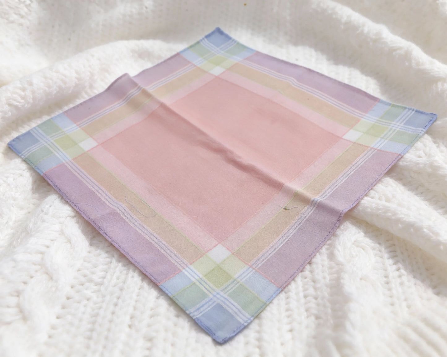 Pastel plaid fabric on a textured white surface