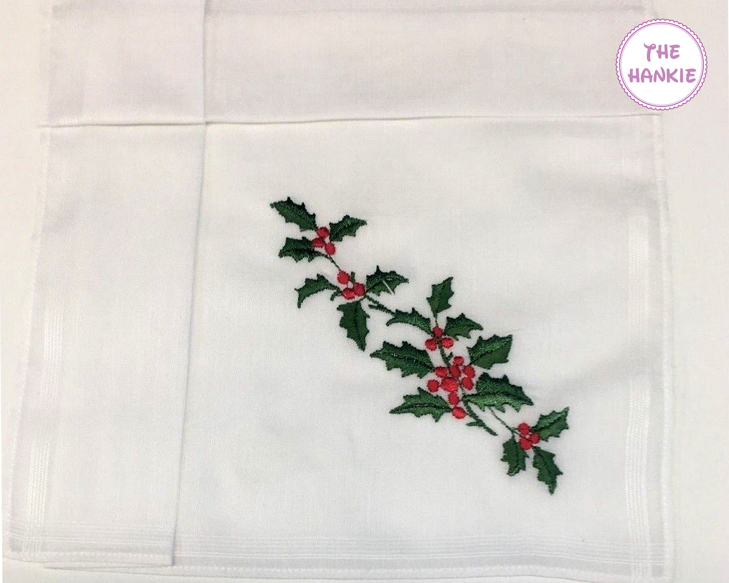 White hankie with embroidered holly design and 'The Hankie' branding.