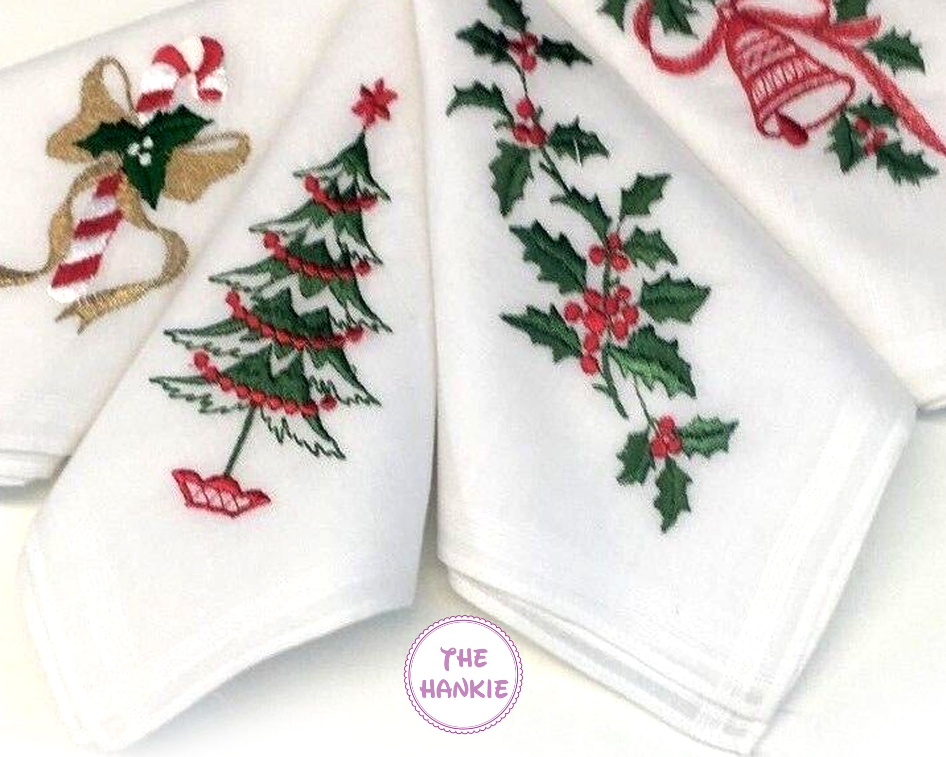 Set of white hankies with Christmas-themed designs including trees, holly, and candy canes.