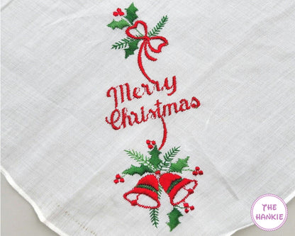 Embroidered Christmas design on a white hankie with 'Merry Christmas' text, red ribbons, and green holly leaves.