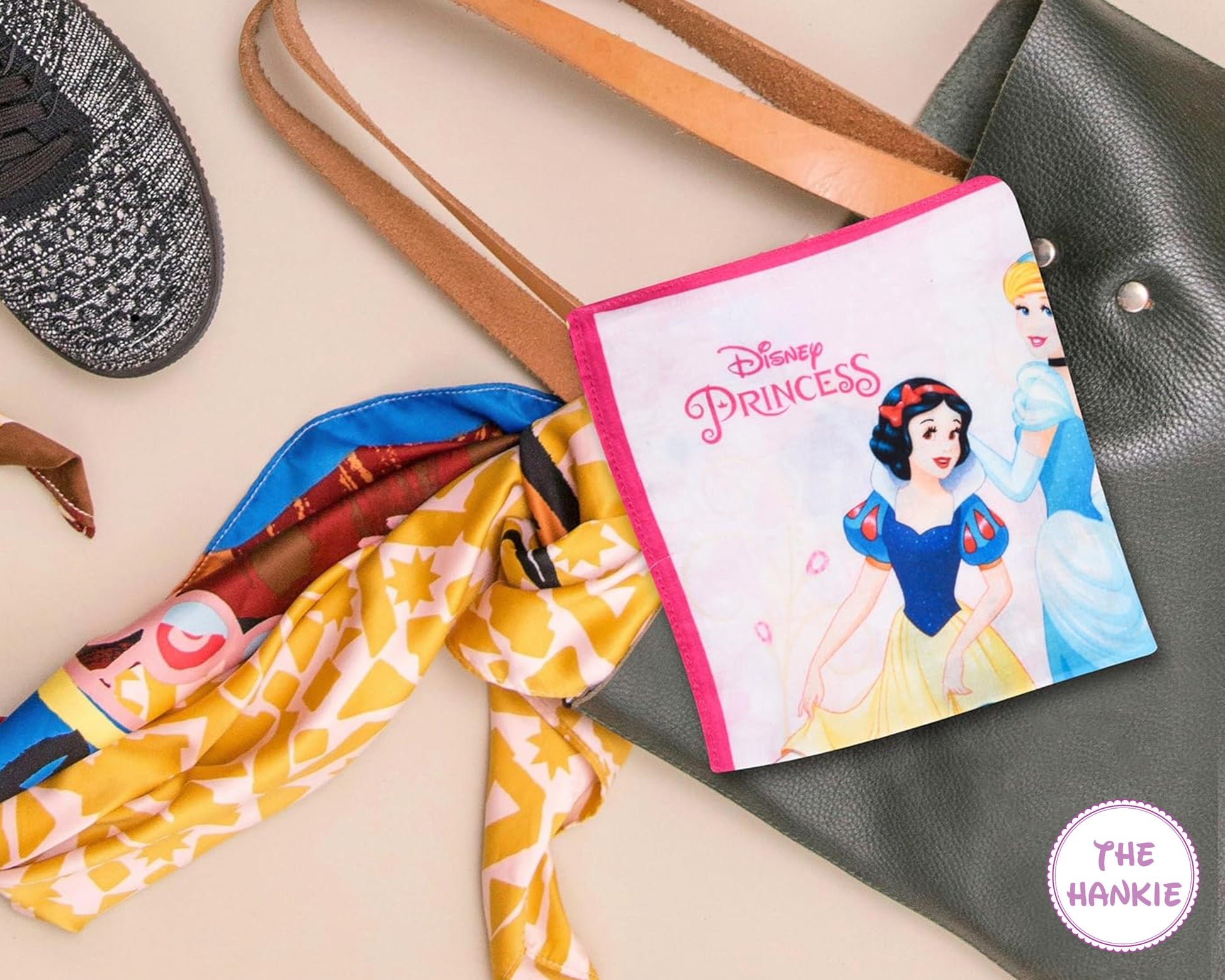 Disney Princess-themed hankie with a handbag and colorful scarf on a beige background