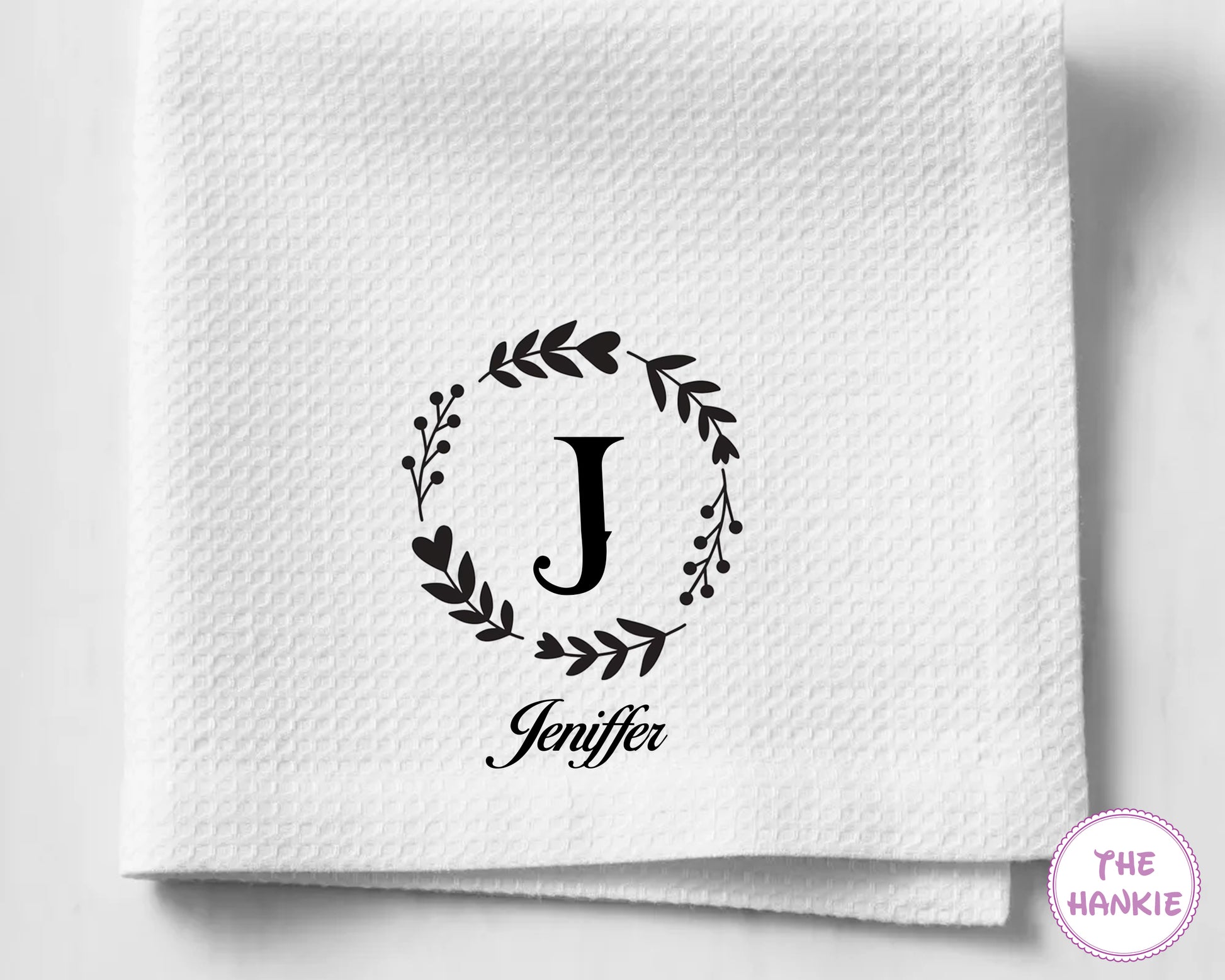 White hankie with 'Jeniffer' and monogram design on a light gray background