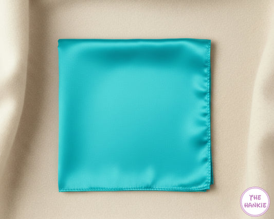 Turquoise satin hankie on a beige fabric background