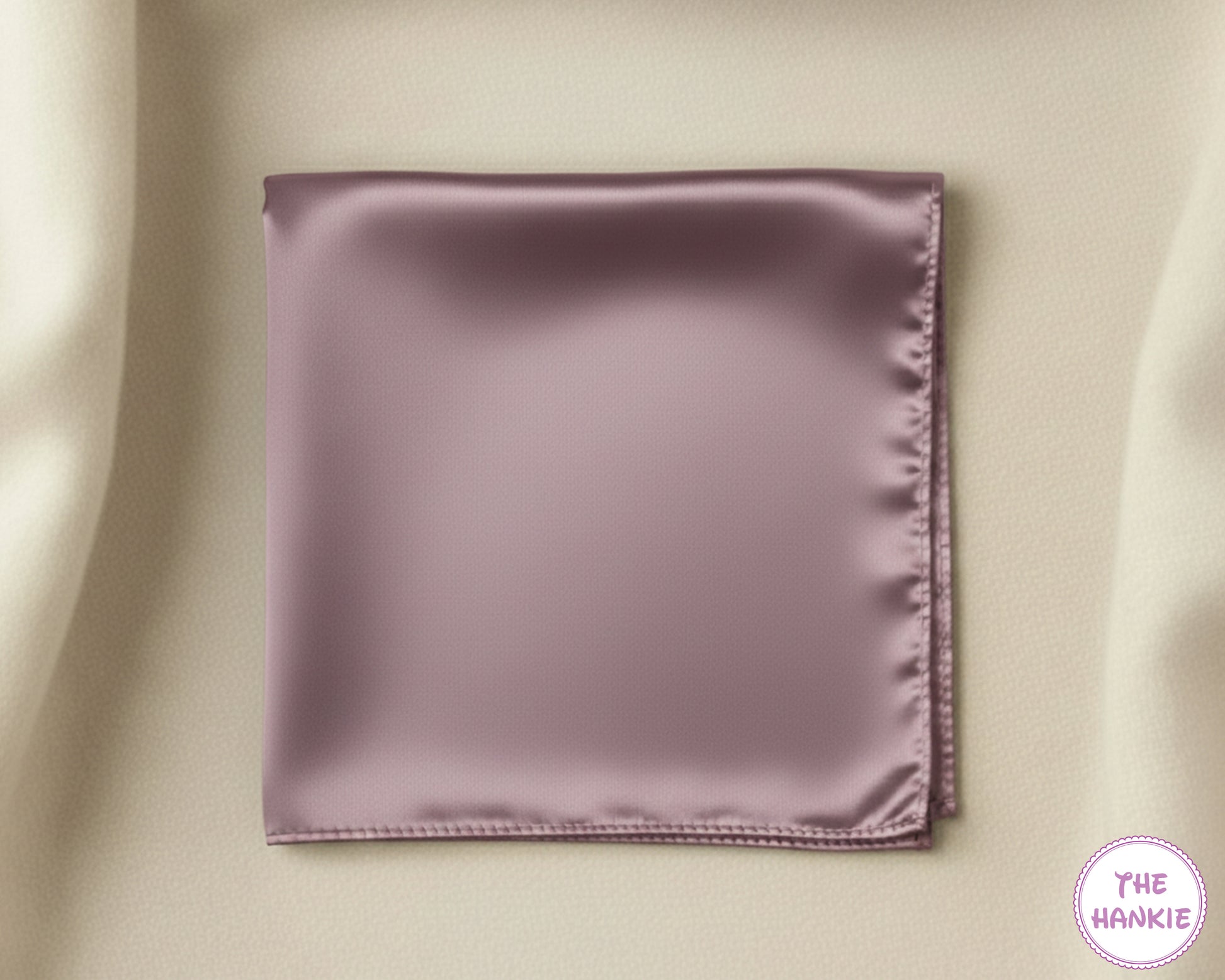 Mauve satin pocket square on a beige fabric background