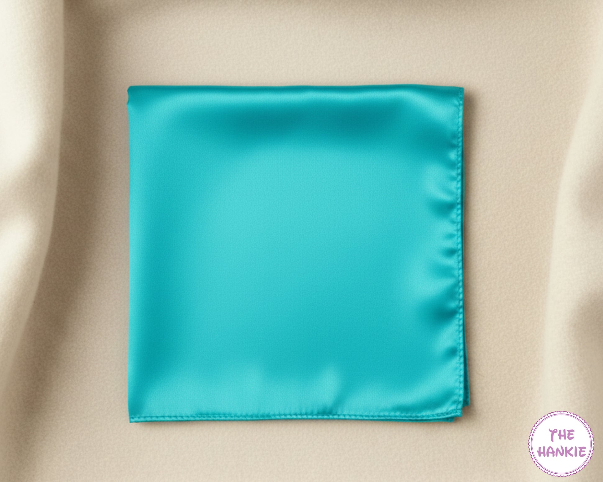 Turquoise satin hankie on a beige fabric background
