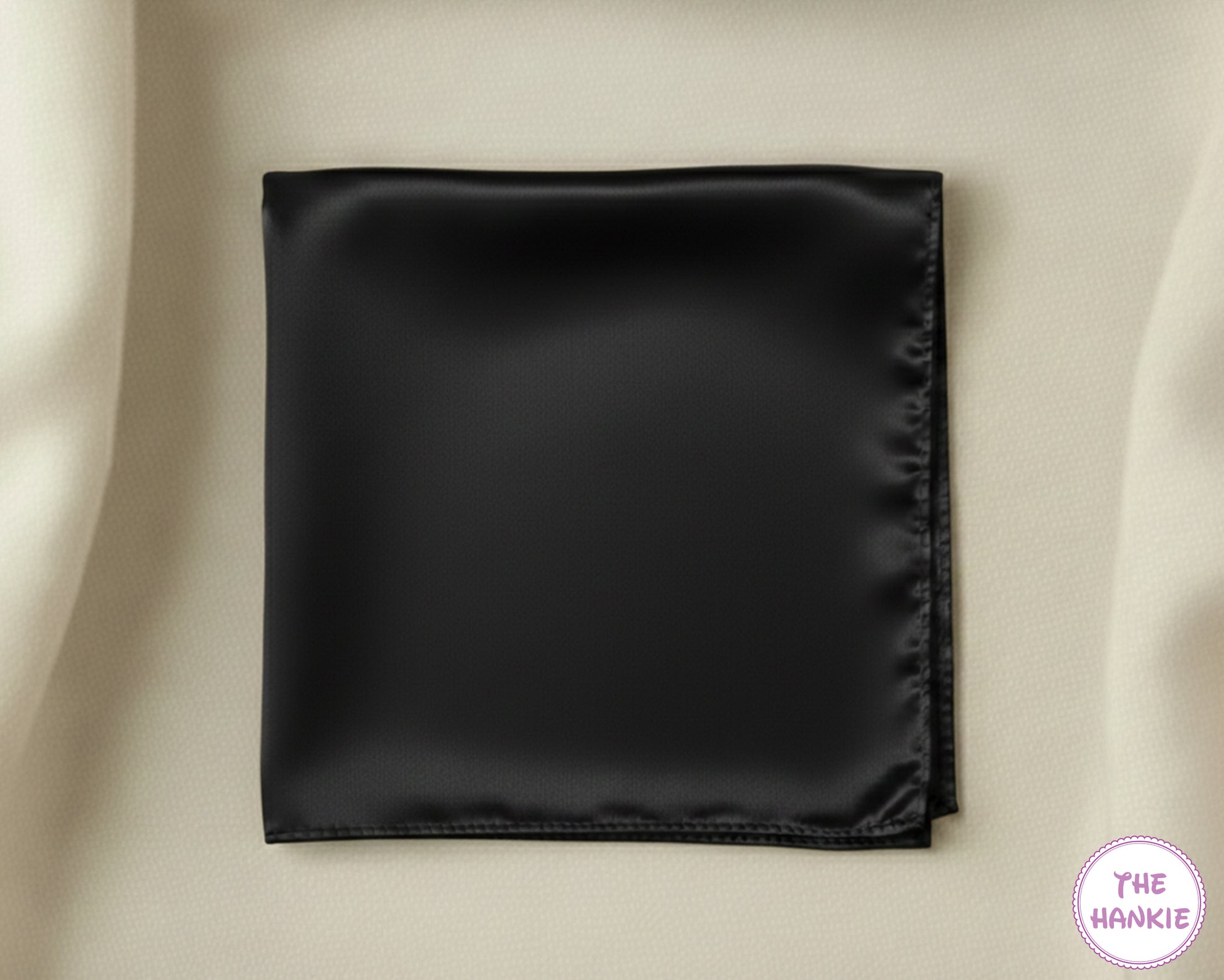 Black satin hankie on a beige background with 'The Hankie' brand logo.