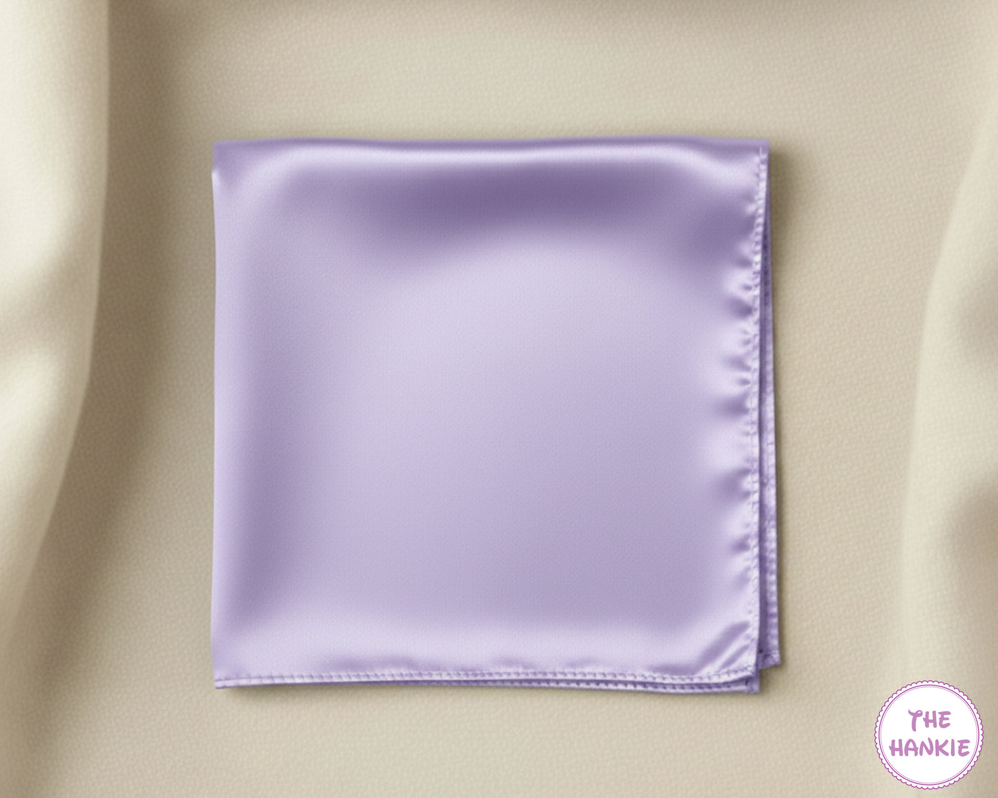 Lavender satin pocket square on a beige background with 'The Hankie' logo.
