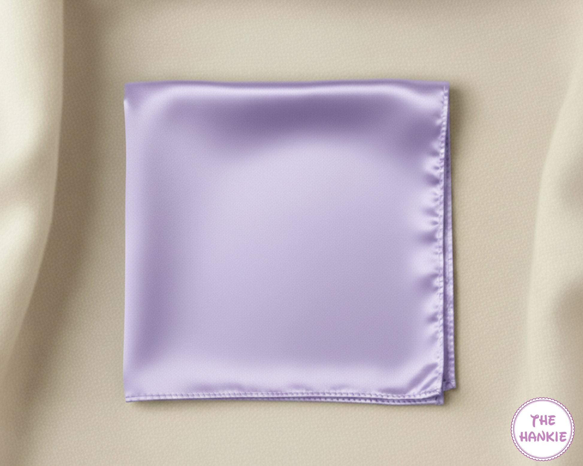 Lavender satin pocket square on a beige background with 'The Hankie' logo.