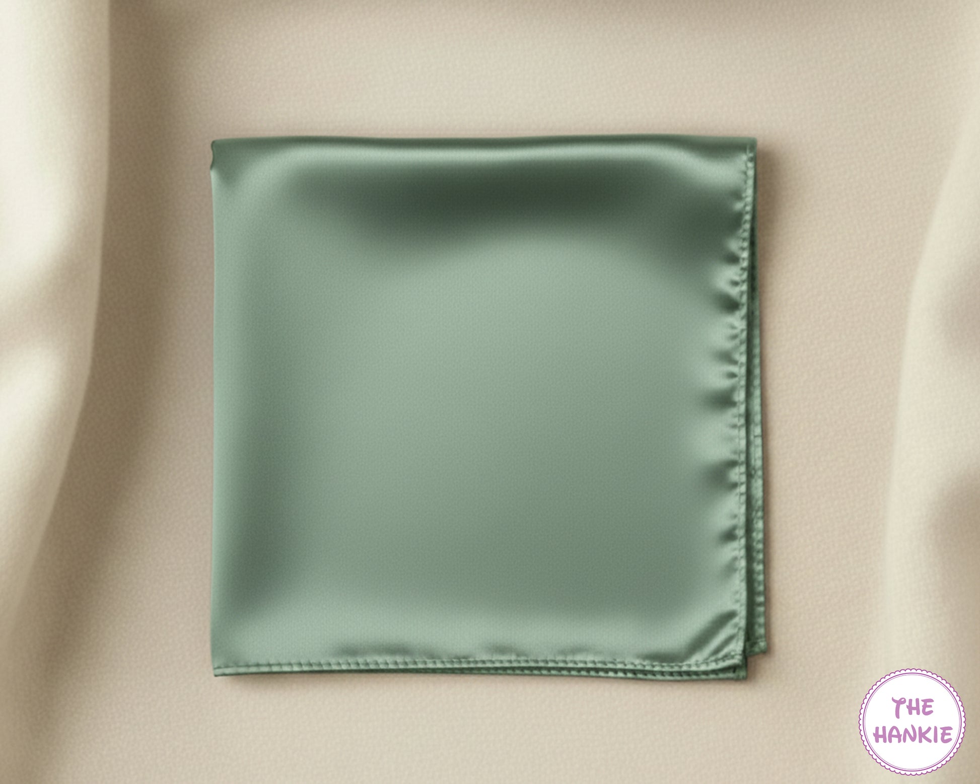 Green satin pocket square on a beige fabric background