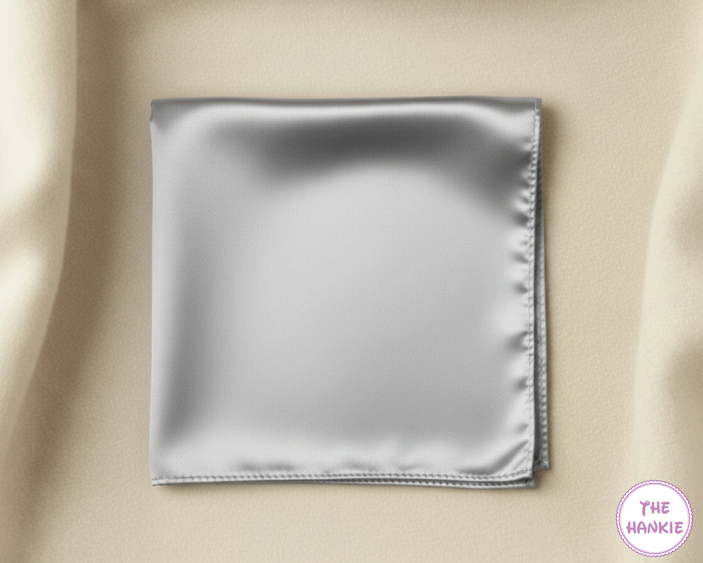 Silver satin hankie on a beige fabric background