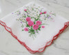 Embroidered handkerchief with pink roses on a marble surface