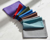 Set of colorful pocket squares hankies arranged in a attractive pattern on a white marble.
