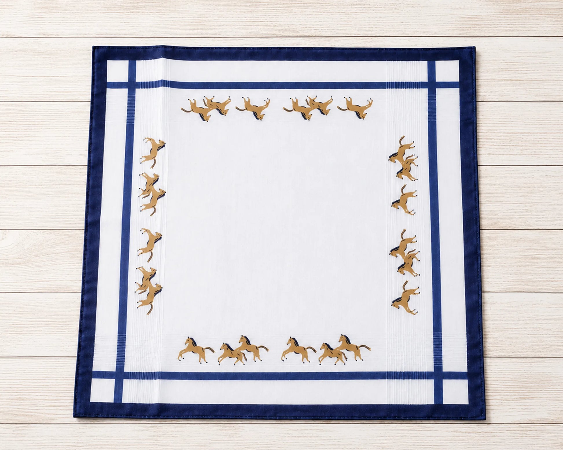 Set of patterned handkerchiefs on a textured surface with a pen and compass.
