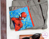 Spider-Man hankie on gray pants with sunglasses and brown leather case.