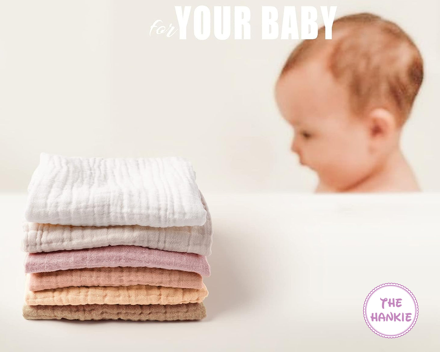 Stack of baby blankets with a baby in the background, featuring 'The Hankie' brand.