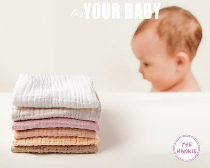Stack of baby blankets with a baby in the background, featuring 'The Hankie' brand.