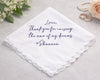 White handkerchief with purple text on a light gray background with flowers and rings.